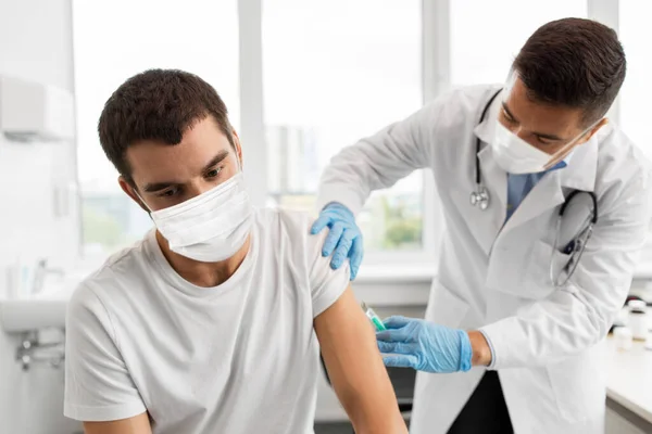 Doente e médico mascarado a fazer vacinação — Fotografia de Stock