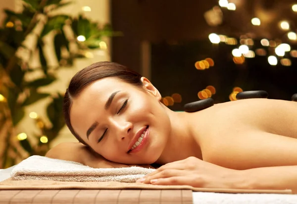 Mulher sorrindo tendo massagem de pedra quente no spa — Fotografia de Stock