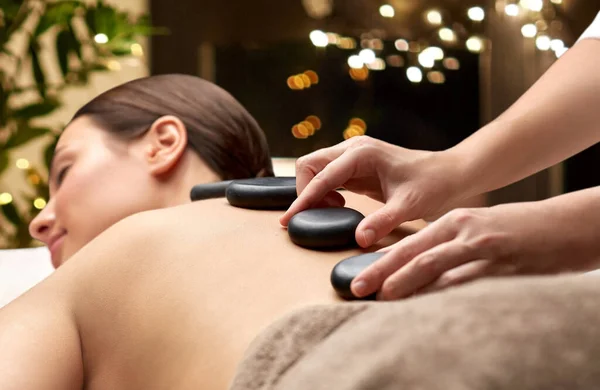 Primer plano de la mujer teniendo masaje de piedra caliente en el spa —  Fotos de Stock