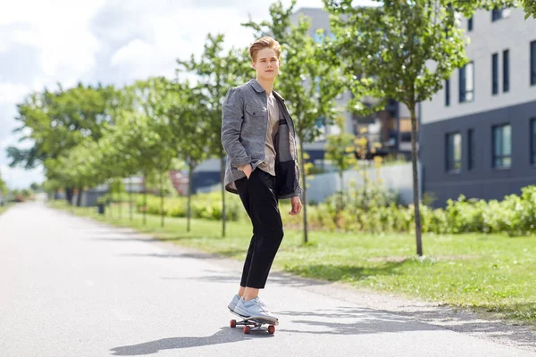 Мальчик-подросток на скейтборде на городской улице — стоковое фото