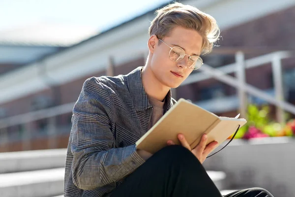 Jonge man met notebook of schetsboek in de stad — Stockfoto