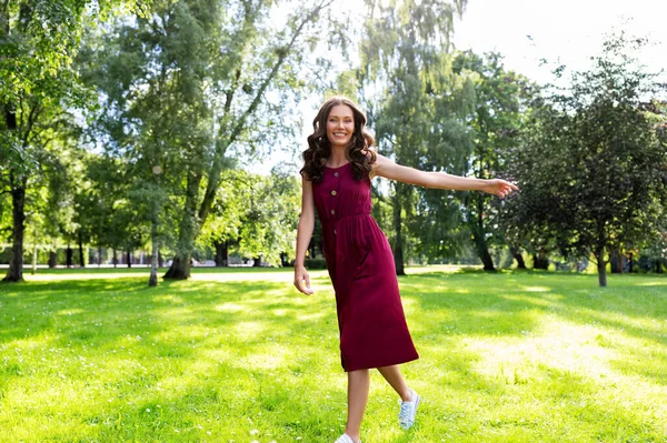 Happy smiling woman walking along summer park — Stock Photo, Image