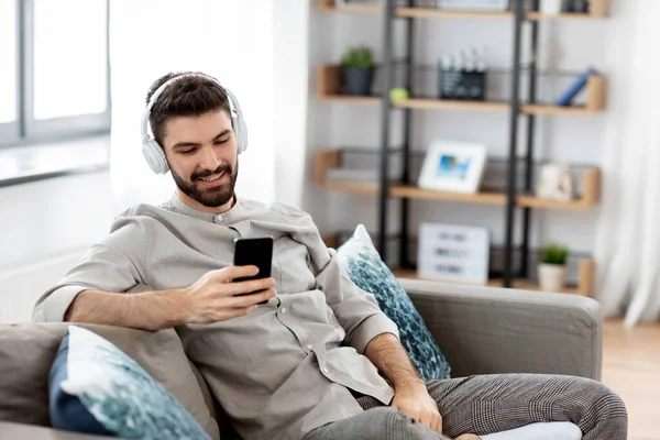 Homem em fones de ouvido ouvir música no smartphone — Fotografia de Stock