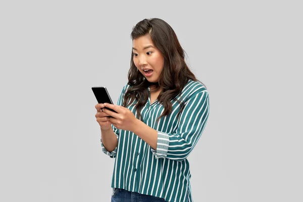 스마트폰을 사용하는 아시아인 여성이 놀란 모습 — 스톡 사진