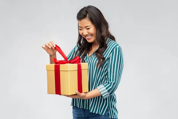 Happy asian woman opening gift box — Stock Photo, Image