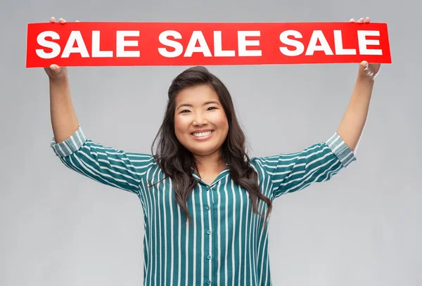 Glücklich lächelnde junge asiatische Frau mit Verkaufsbanner — Stockfoto