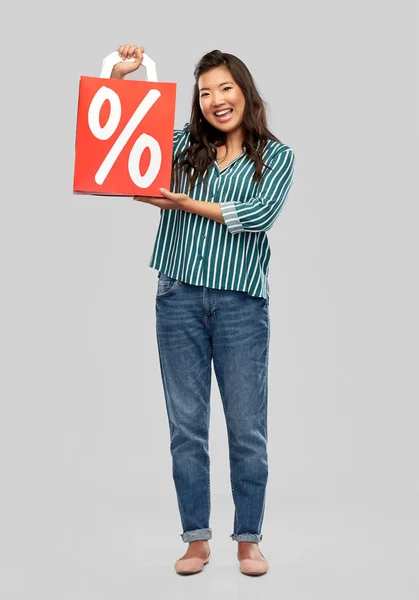 Asijská žena s procentuálním znaménkem na nákupních taškách — Stock fotografie