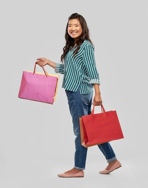幸せなアジアの女性が買い物袋を持って歩く — ストック写真