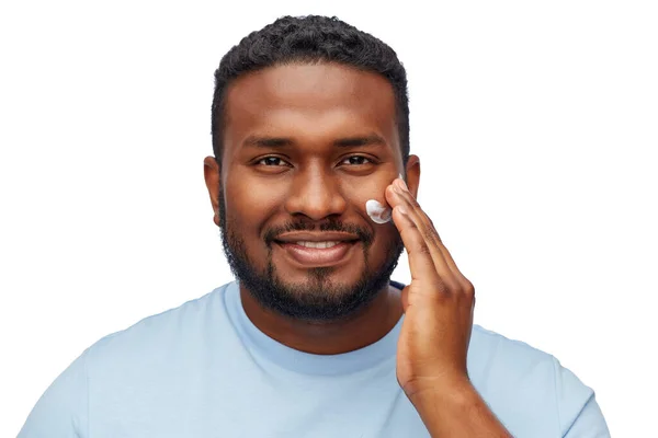 Афроамериканський чоловік наносить зволожувач обличчю — стокове фото