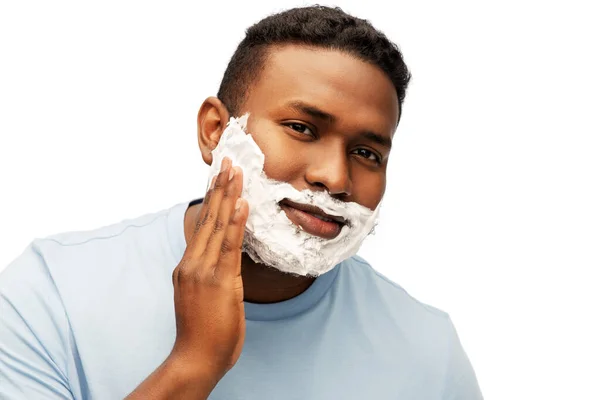Uomo africano americano che applica schiuma da barba al viso — Foto Stock