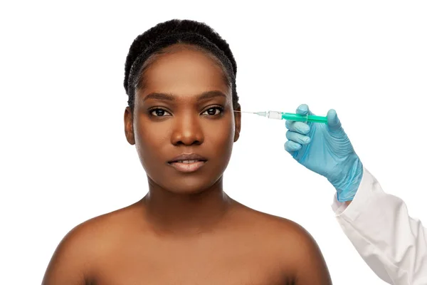 Africká žena a ruka v rukavici s injekční stříkačkou — Stock fotografie