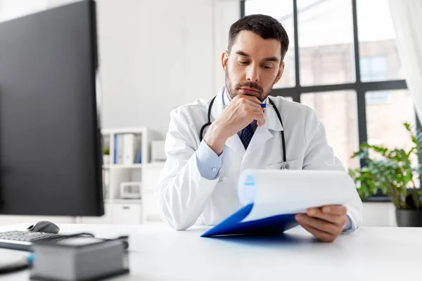 Docteur masculin stressé avec presse-papiers à l'hôpital — Photo