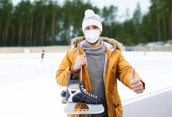 Homem em máscara mostrando polegares para cima na pista de patinação — Fotografia de Stock