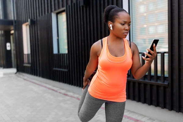 야외에서 스마트폰으로 운동하는 아프리카 여성 — 스톡 사진