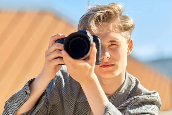 Jovem com câmera fotografando ao ar livre — Fotografia de Stock