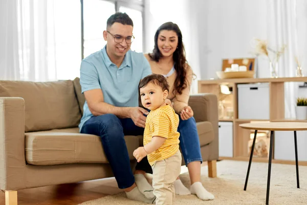 Famiglia felice con bambino seduto sul divano a casa — Foto Stock