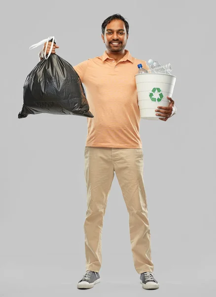Улыбающийся индиец сортирует бумагу и пластиковые отходы — стоковое фото