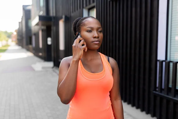 Sportieve Afrikaanse vrouw roepen op smartphone in de stad — Stockfoto