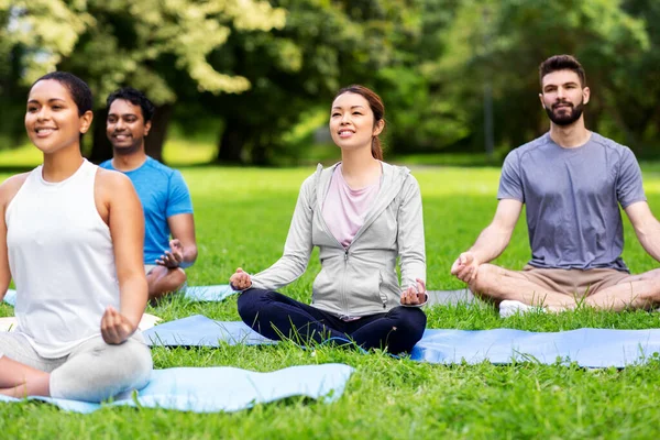 Group of people doing yoga at summer park — Stock Photo, Image