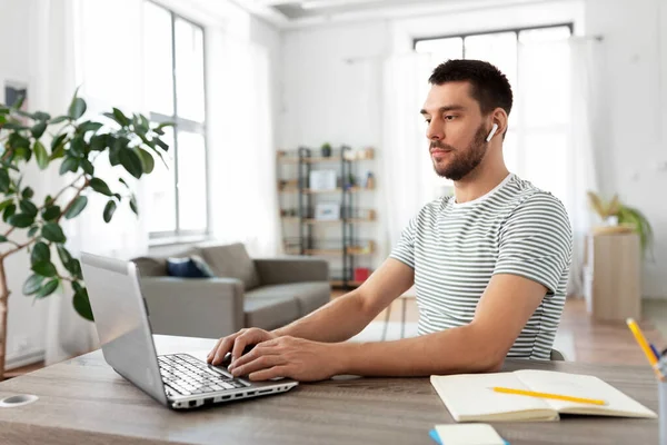 Uomo con laptop e auricolari a casa ufficio — Foto Stock