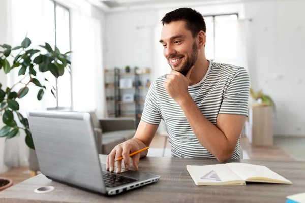 Homem com laptop trabalhando no escritório em casa — Fotografia de Stock