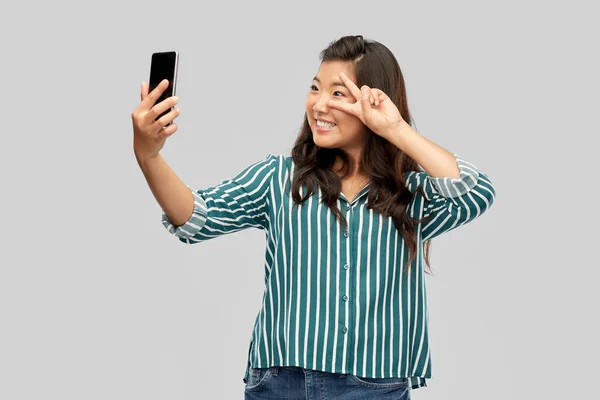 Lachende aziatische vrouw het nemen van selfie door smartphone — Stockfoto