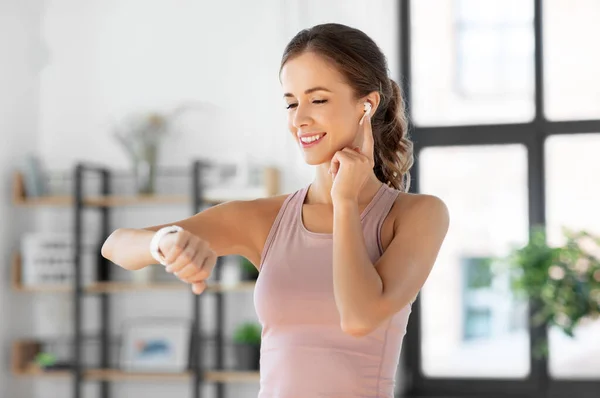 Frau mit Smartwatch und Kopfhörer beim Sport — Stockfoto