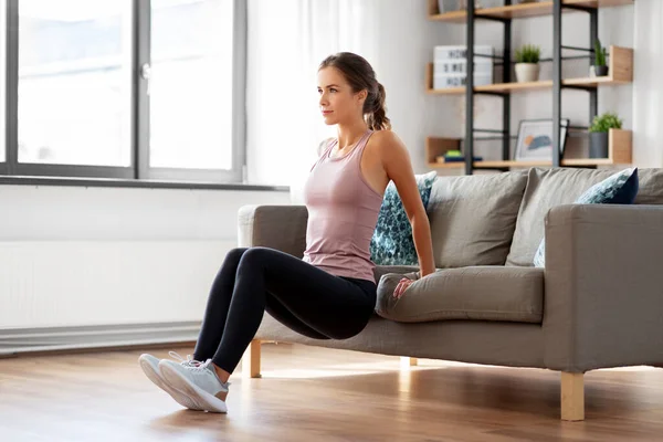 Mujer joven haciendo ejercicio en casa — Foto de Stock