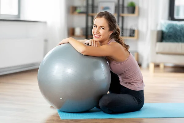 Glückliche junge Frau mit Fitnessball zu Hause — Stockfoto