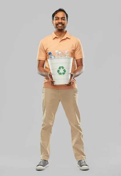 Lächelnder junger indischer Mann beim Sortieren von Plastikmüll — Stockfoto