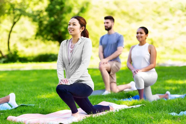 Groep mensen die yoga doen in het zomerpark — Stockfoto