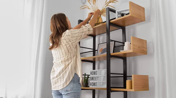 Mujer decorando casa con flores secas en jarrón — Foto de Stock