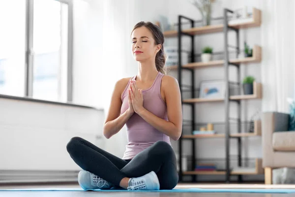 Mujer haciendo yoga en pose de loto en casa — Foto de Stock