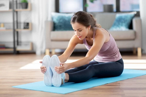 Femeie tânără care face exerciții de yoga acasă — Fotografie, imagine de stoc