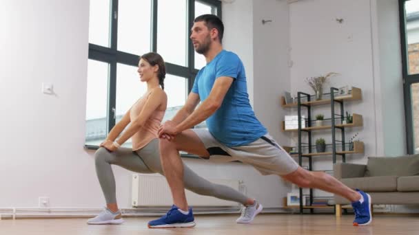 Couple exercising and doing lunge at home — Stock Footage Couple exercising and doing lunge at home Stock Footage