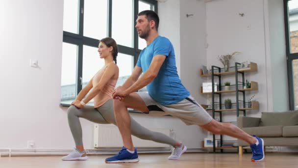 Pareja haciendo ejercicio y haciendo embestida en casa — Vídeos de Stock