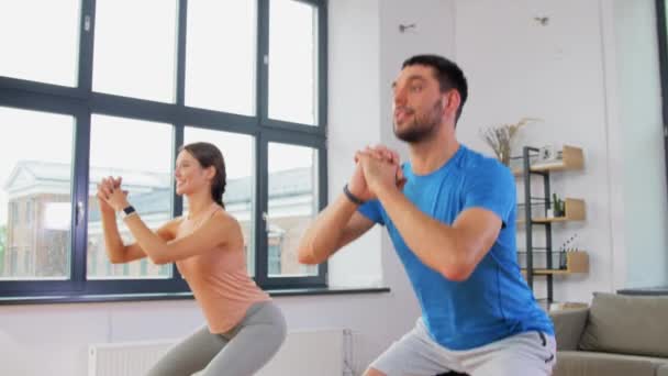 Feliz pareja haciendo ejercicio y haciendo sentadillas en casa — Vídeos de Stock