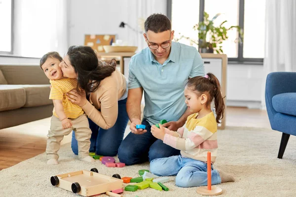 Família feliz pálido com brinquedos de madeira em casa — Fotografia de Stock