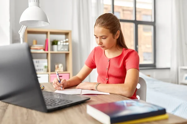Adolescente estudante menina escrevendo para notebook em casa — Fotografia de Stock
