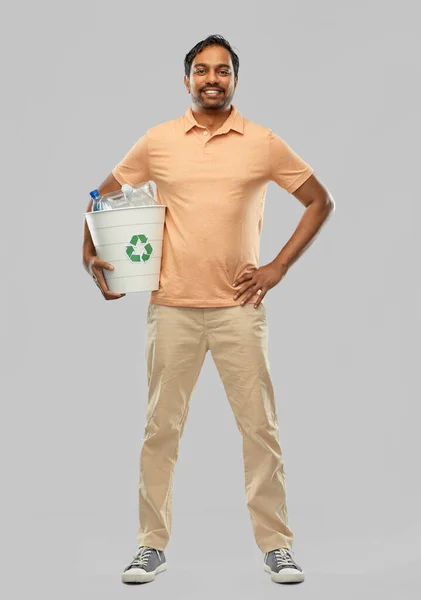 Улыбающийся молодой индиец сортирует пластиковые отходы — стоковое фото
