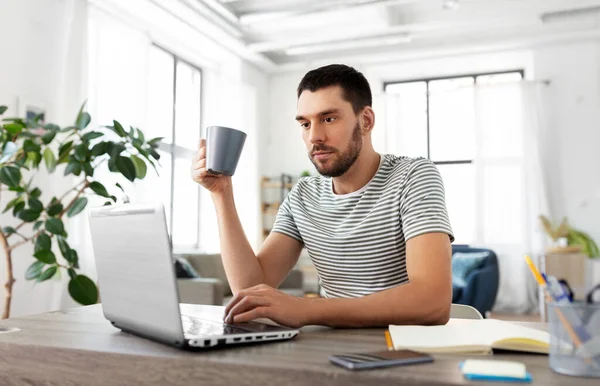 Hombre con portátil beber café en casa oficina — Foto de Stock