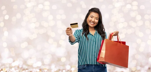 Aziatische vrouw met boodschappentassen en creditcard — Stockfoto