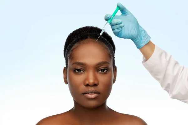 Africká žena a ruka v rukavici s injekční stříkačkou — Stock fotografie