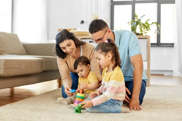 Glückliche Familie spielt zu Hause mit Pyramidenspielzeug — Stockfoto