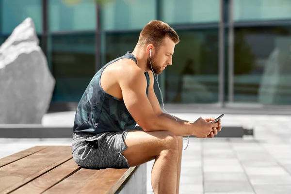 young athlete man with earphones and smartphone