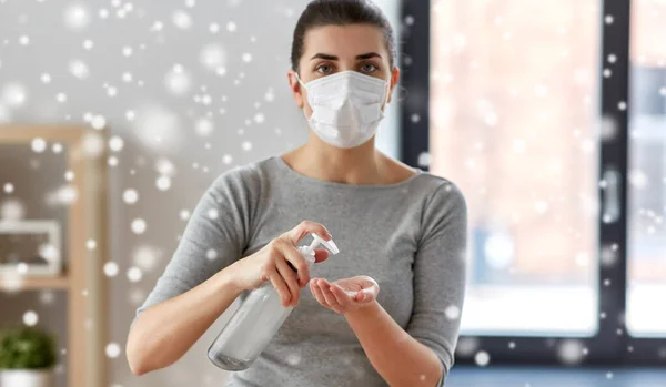 Close-up van vrouw in masker van toepassing hand sanitizer — Stockfoto