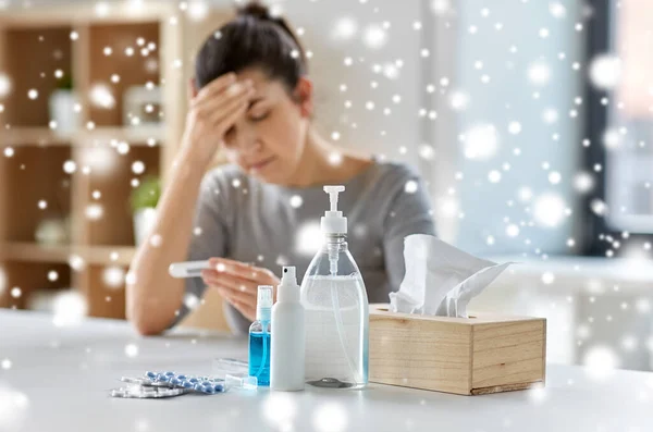 Geneesmiddelen en zieke vrouw met thermometer thuis — Stockfoto