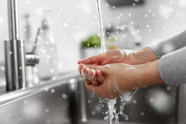 Vrouw wassen handen met vloeibare zeep in de keuken — Stockfoto