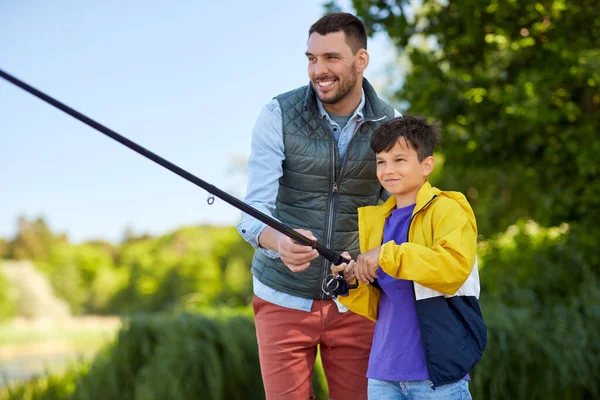 Gelukkig lachende vader en zoon vissen op de rivier — Stockfoto