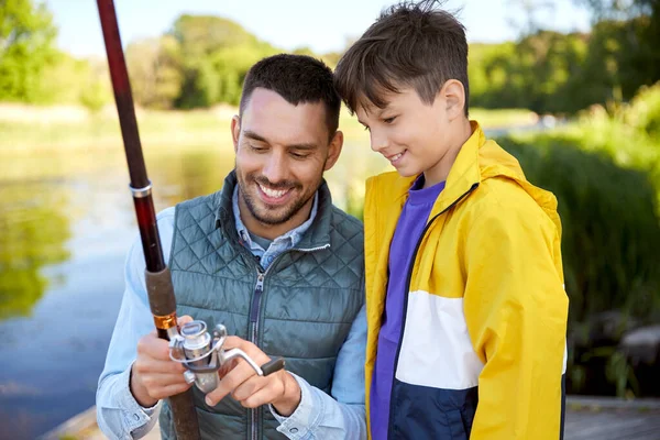 Feliz sorrindo pai e filho pesca no rio — Fotografia de Stock